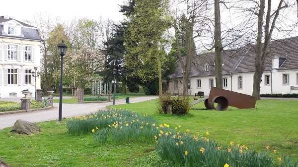 Bild des Rundwegs im Garten Schloss Morsbroichs mit Vorburg und Ausstellungsstücke
